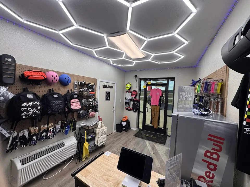 Helmets, bags, and gloves displayed on the gear wall at E-Ride'z
