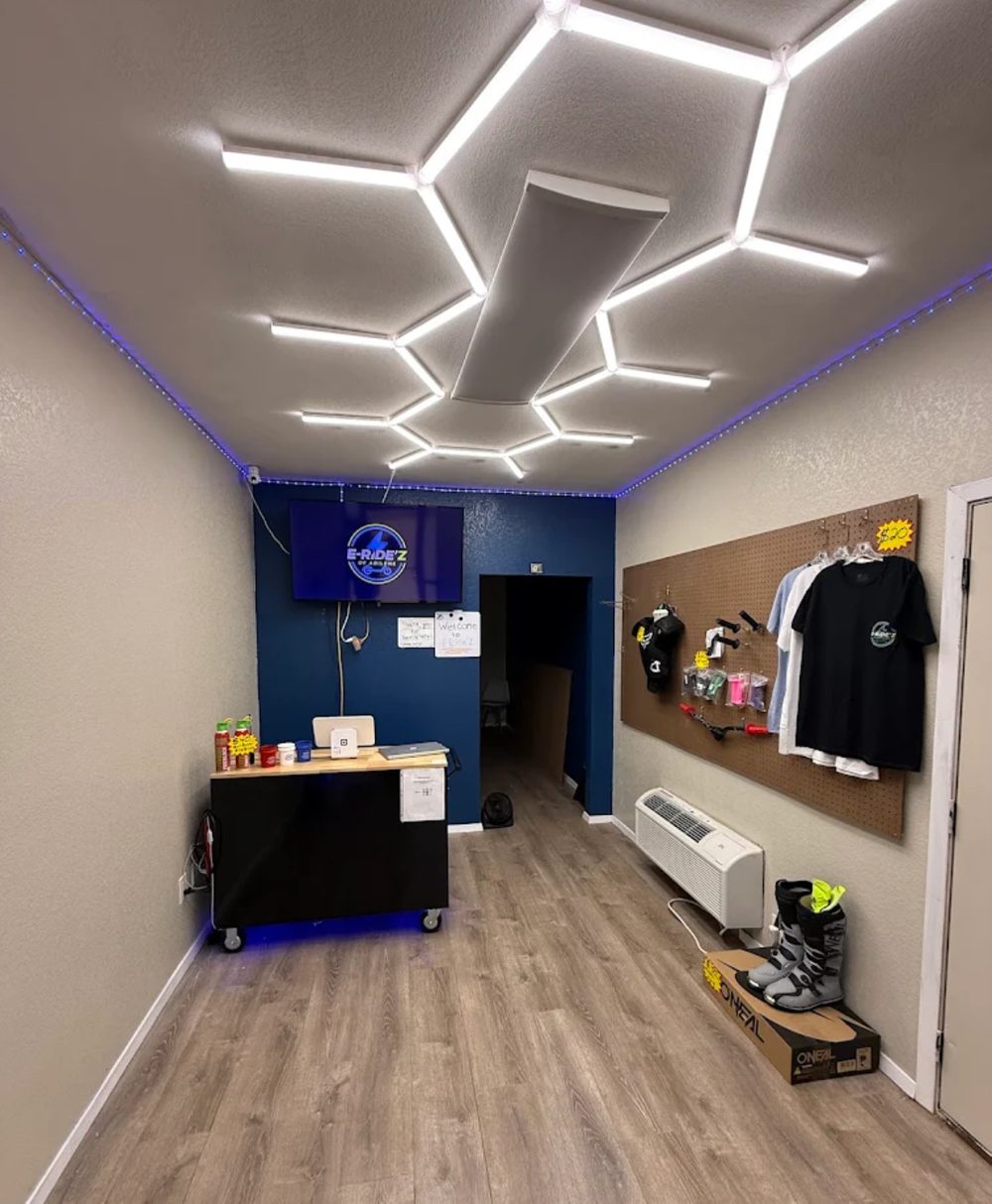 Inside the E-Ride'z showroom — hex LED lighting, gear wall, and checkout counter